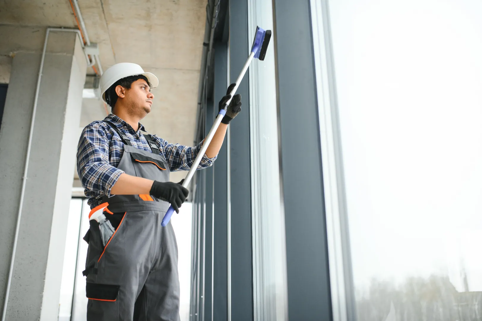 Professional cleaner washing windows after construction